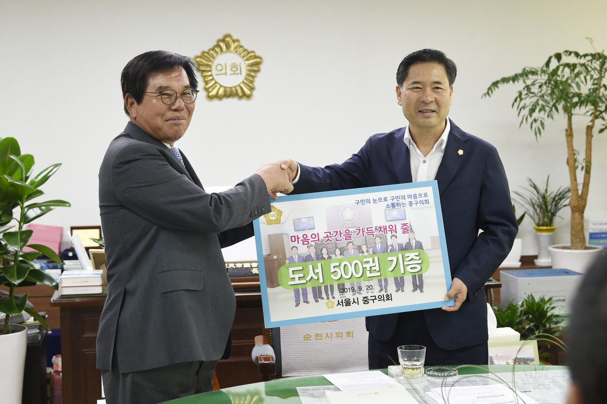 서정진 순천시의회 의장이 서울 중구의회 조영훈의장으로 부터 도서를 기증받는다